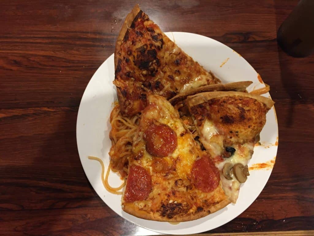Three pizza slices and spaghetti at Pizza In