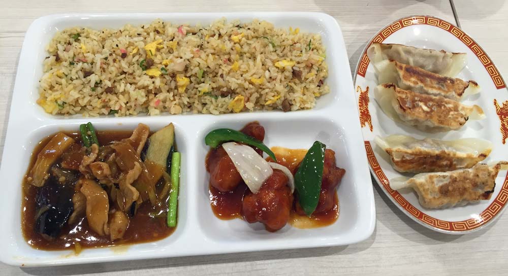 Rice, sweet and sour chicken and pork, chili and aubergine and a side of gyoza