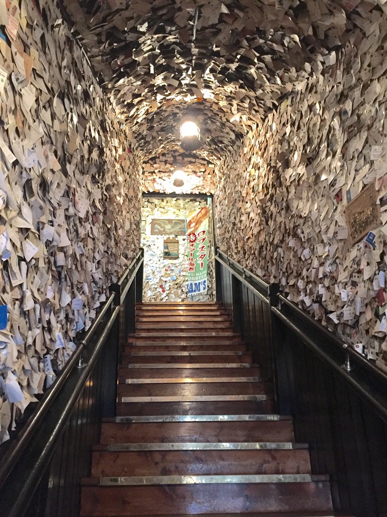 Stairs up to Sam's Anchor Inn covered in business cards